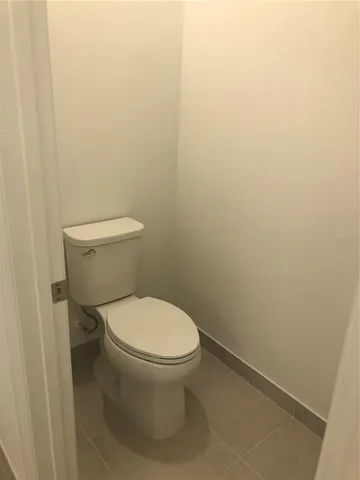 a white toilet sitting next to a white wall