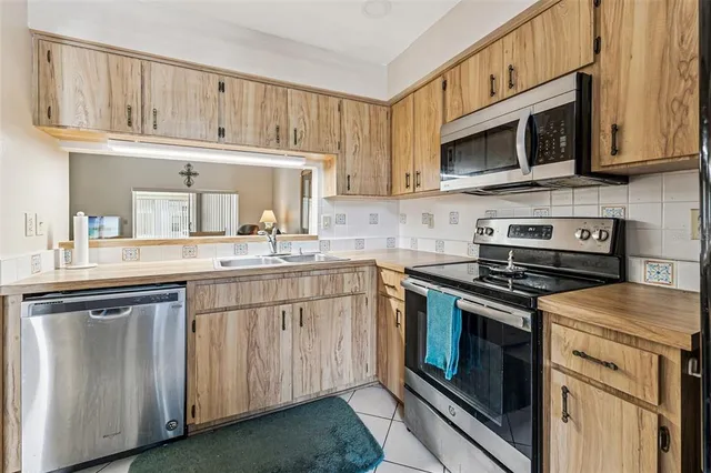 a kitchen with stainless steel appliances granite countertop a stove microwave and cabinets