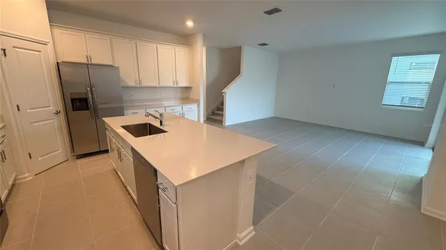 a kitchen that has a cabinets a sink a window and stainless steel appliances