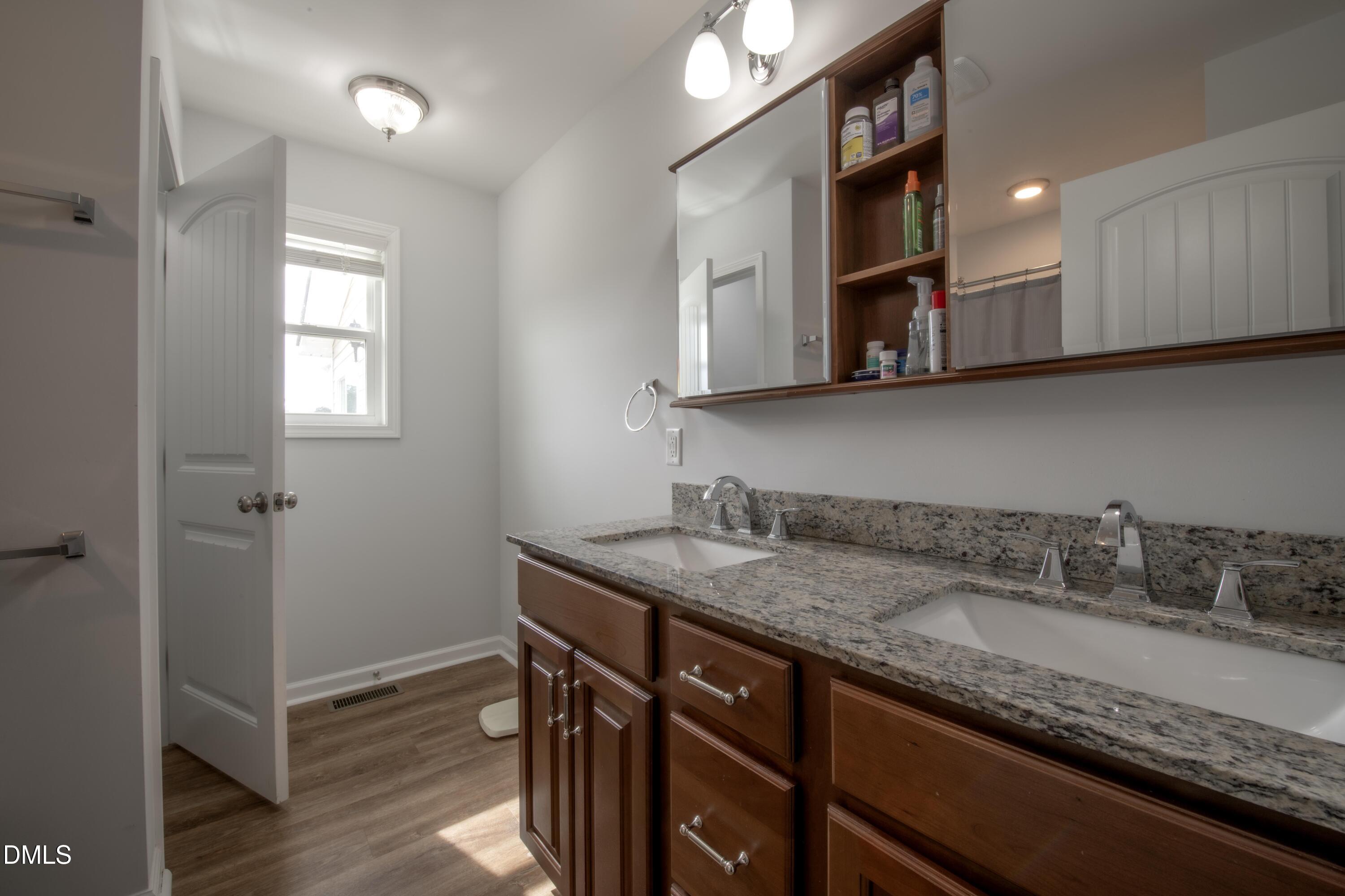 130 Hardy Road Wendell, NC 27591 - Photo 19 of 34 a bathroom with a granite countertop sink a mirror and cabinets
