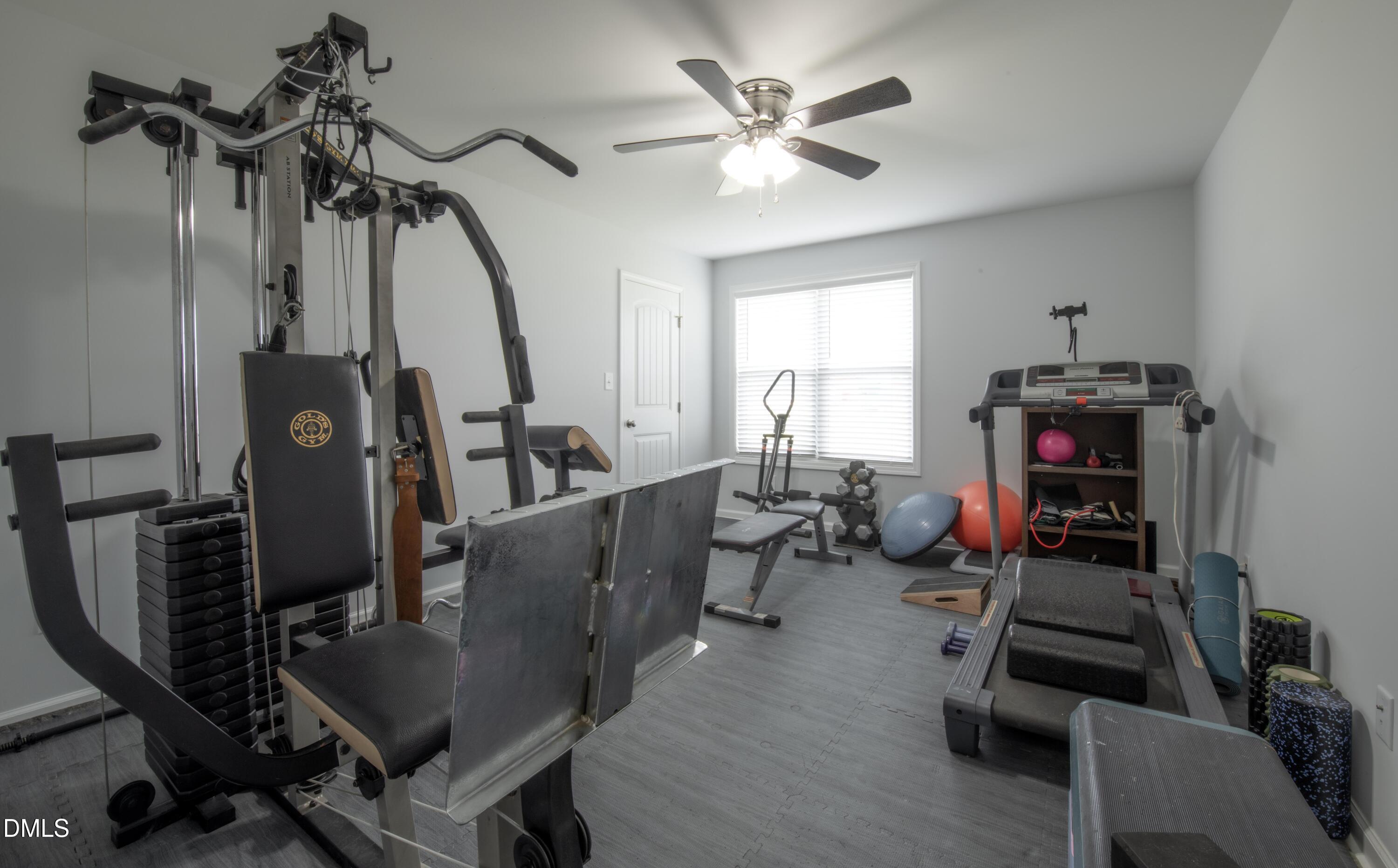 130 Hardy Road Wendell, NC 27591 - Photo 24 of 34 a living room with furniture a flat screen tv and gym equipment