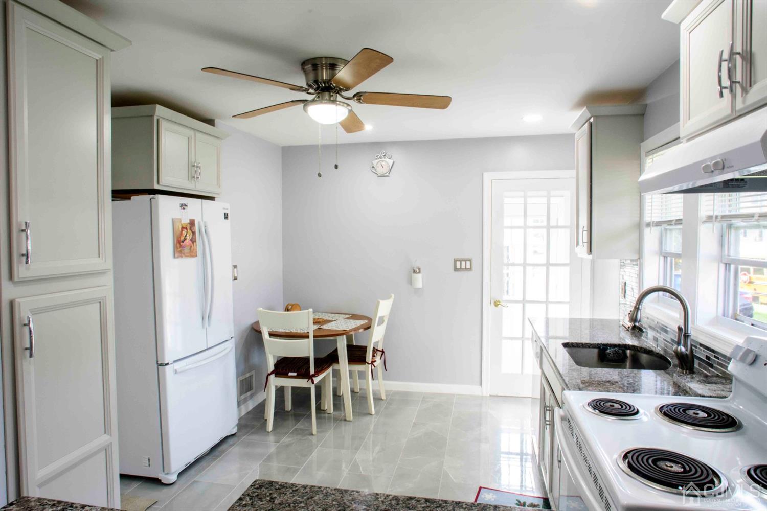 2 High Point Road East Brunswick, NJ 08816 - Photo 5 of 36 a kitchen with stainless steel appliances granite countertop a sink a stove a refrigerator and island with wooden floor