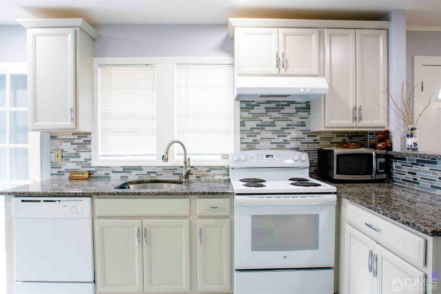 2 High Point Road East Brunswick, NJ 08816 - Photo 7 of 36 a kitchen with granite countertop white cabinets and white appliances