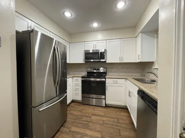 a kitchen with stainless steel appliances and refrigerator