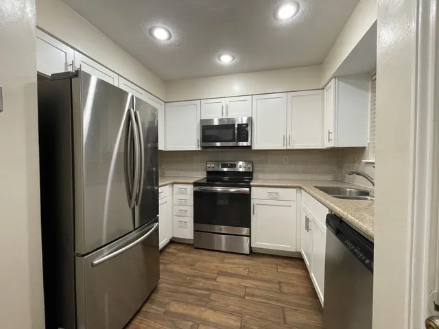 a kitchen with stainless steel appliances and refrigerator
