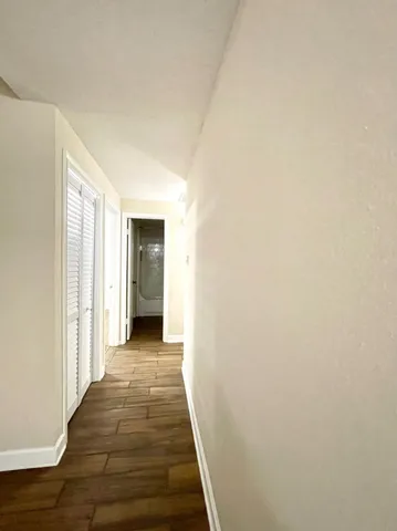 a view of a hallway with wooden floor