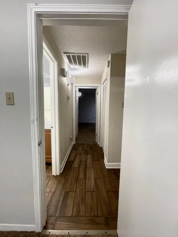 a view of a hallway with wooden floor and staircase