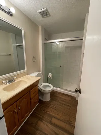 a bathroom with a granite countertop sink toilet and shower