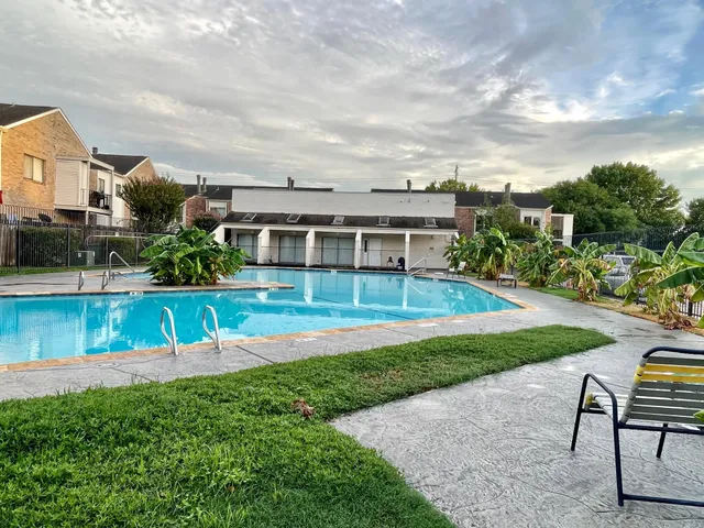 a view of house with a big yard and potted plants
