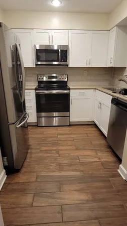 a kitchen with appliances a sink and cabinets