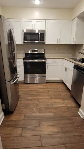 a kitchen with appliances a sink and cabinets