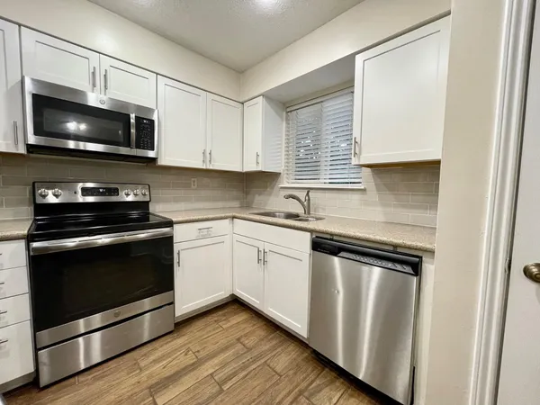 a kitchen with a sink stove and microwave