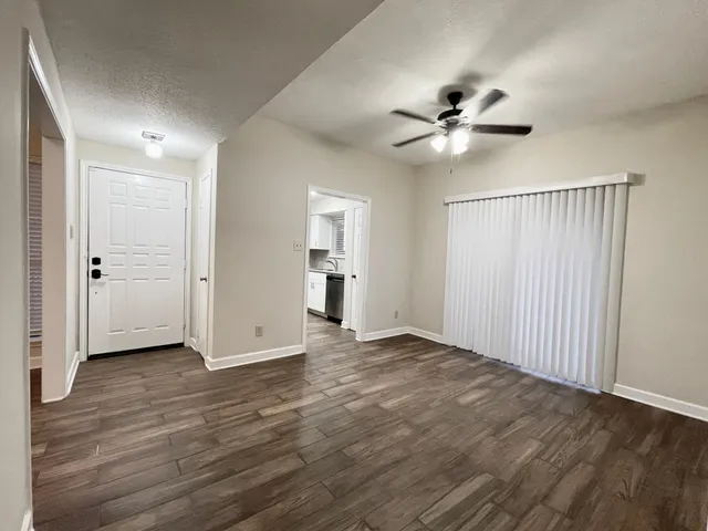 a view of an empty room with a ceiling fan