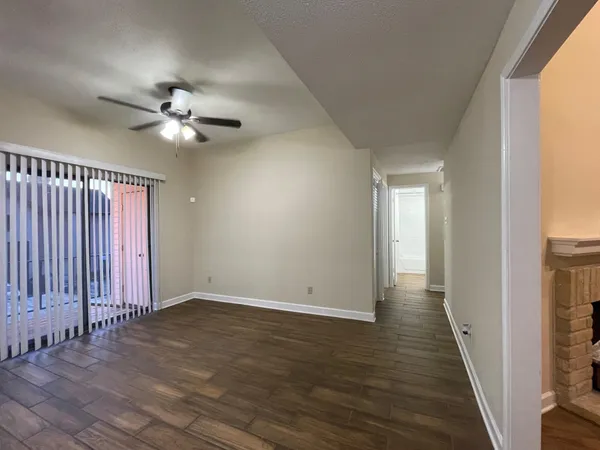an empty room with wooden floor and ceiling fan