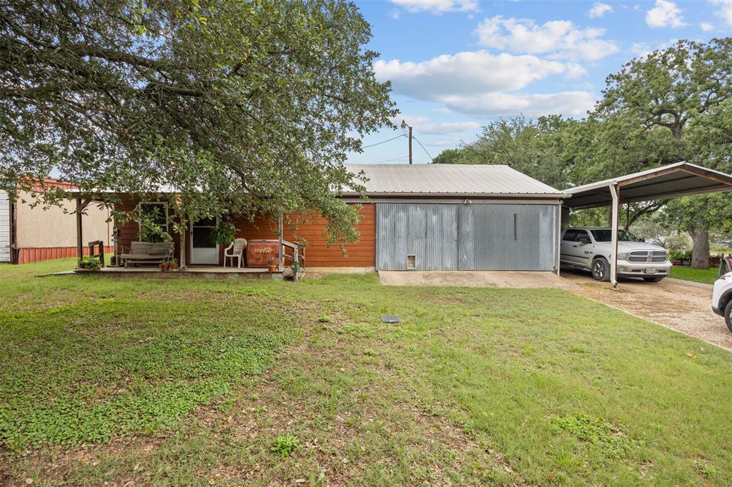 153 Center Loop Whitney, TX 76692 - Photo 2 of 21 a front view of a house with garden