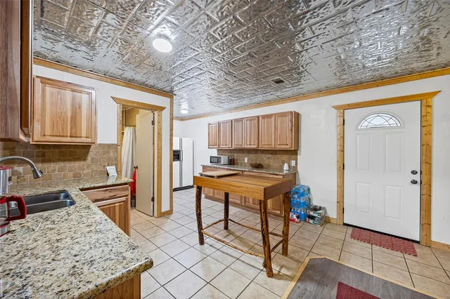 a kitchen with stainless steel appliances granite countertop a sink and a refrigerator