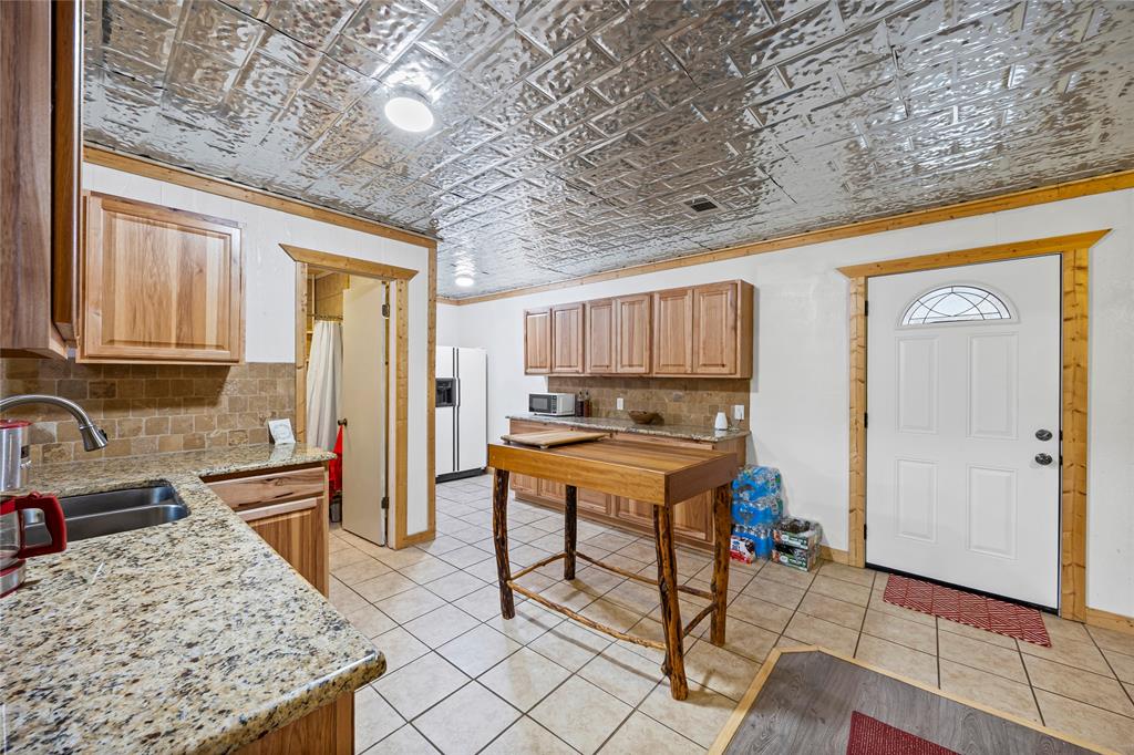 153 Center Loop Whitney, TX 76692 - Photo 7 of 21 a kitchen with stainless steel appliances granite countertop a sink and a refrigerator