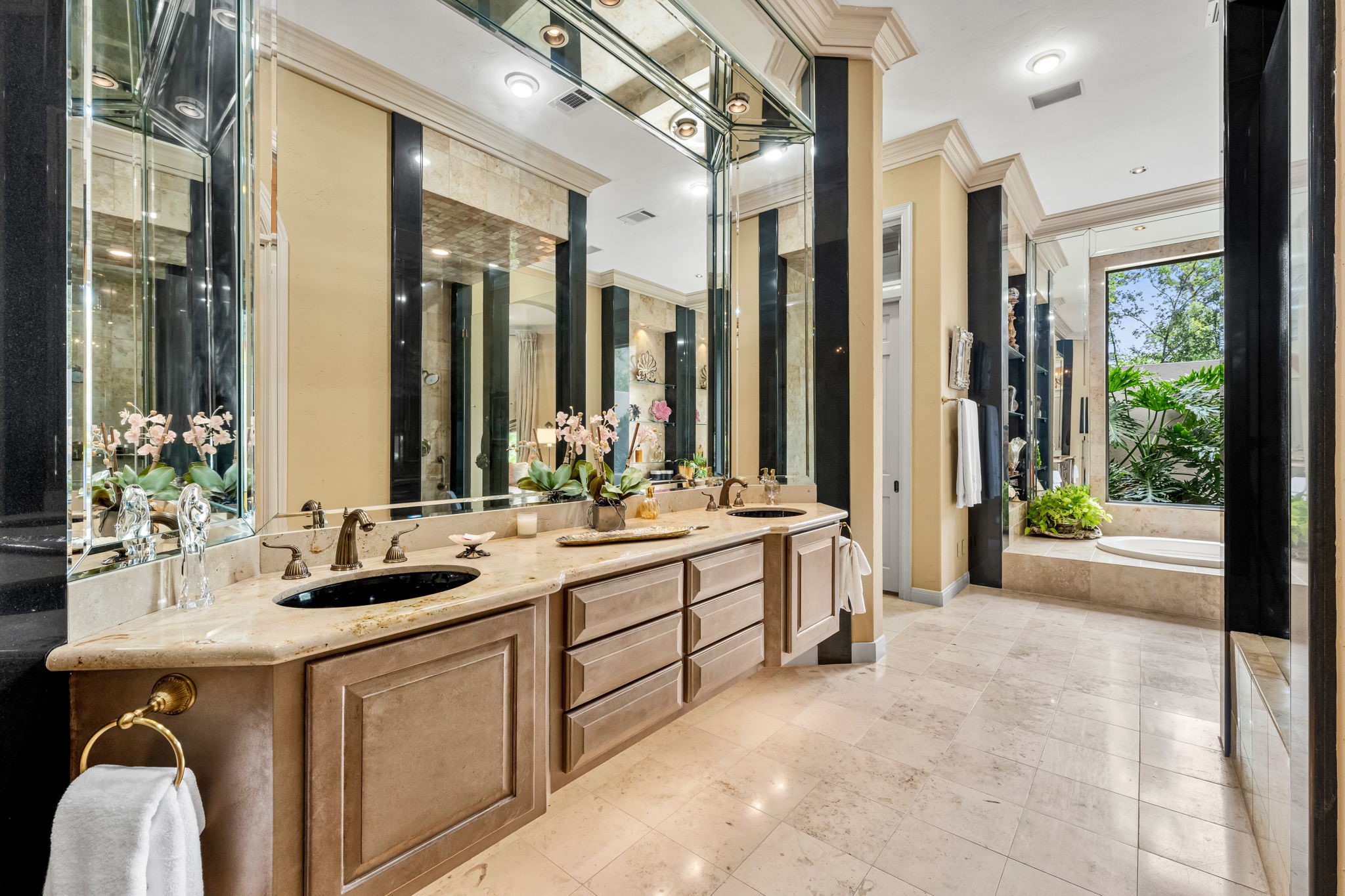 6 Mott Lane Houston, TX 77024 - Photo 23 of 50 Expansive primary bath with dual vanities, custom cabinetry, and elegant stone finishes throughout. Oversized mirrors, and spa-like layout with serene garden views, creating a luxurious and functional retreat.