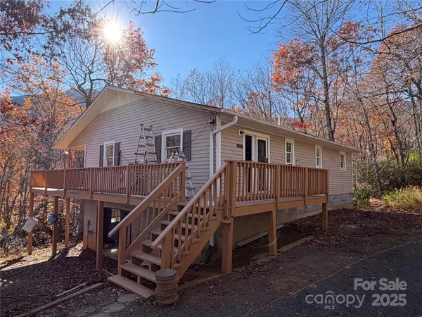 a view of a house with a yard and wooden deck