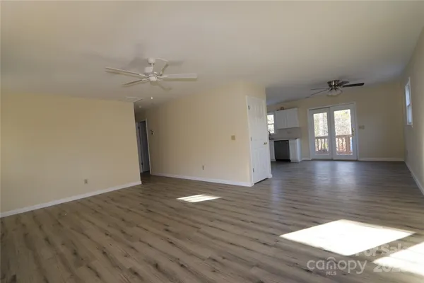 a view of an empty room with window and wooden floor