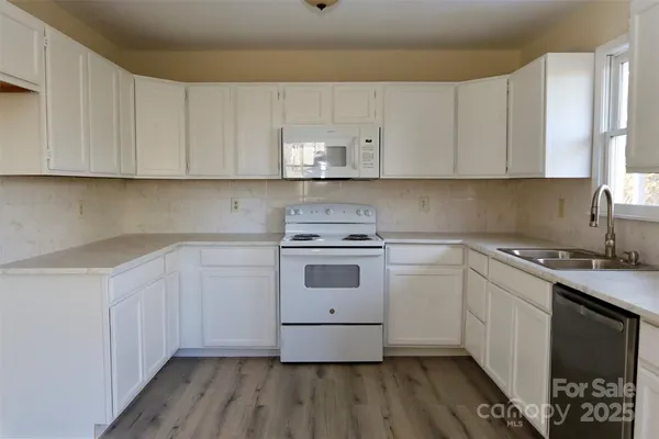 a kitchen with a white cabinets and white appliances