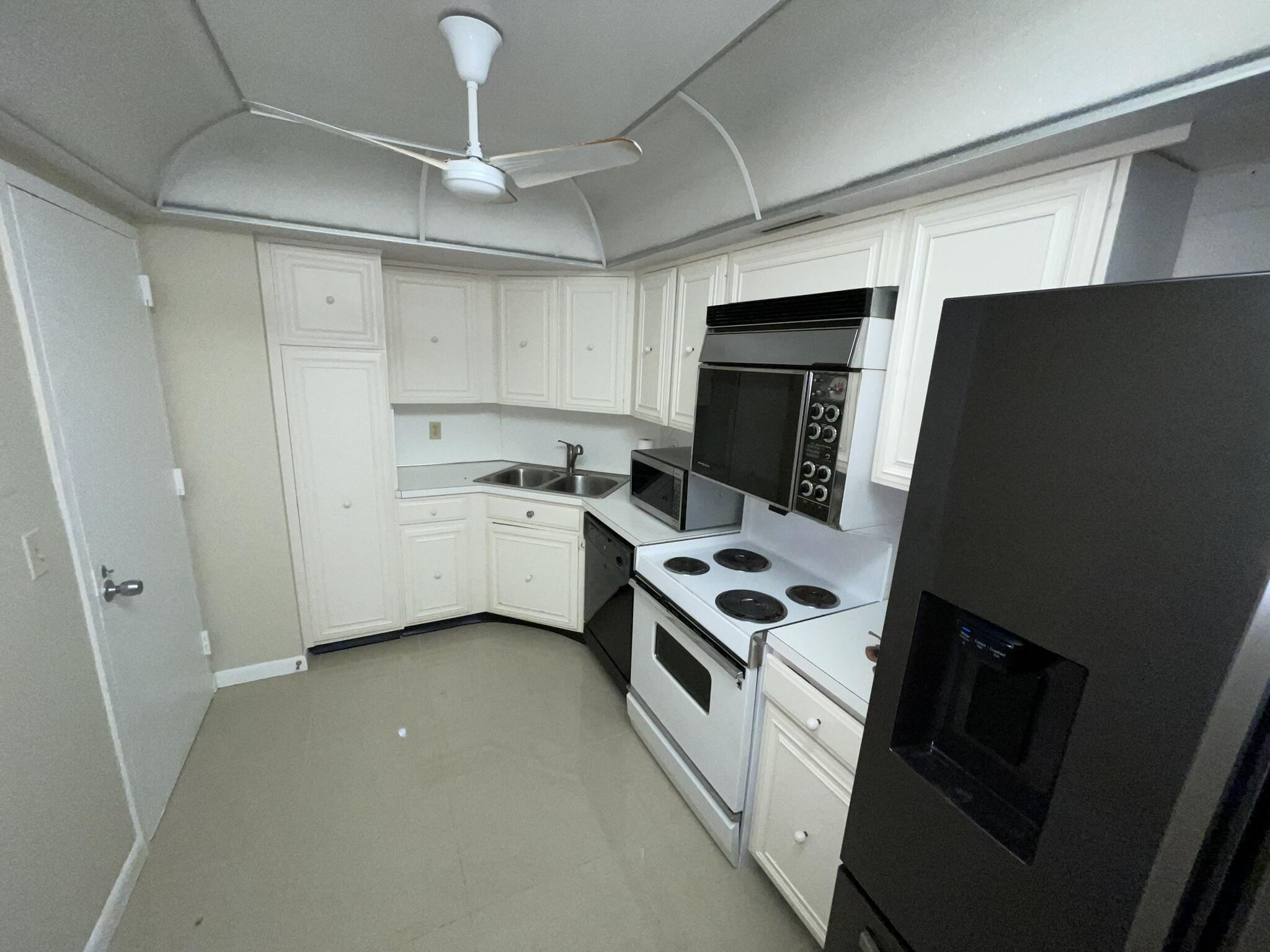 a kitchen with stainless steel appliances a stove refrigerator a sink dishwasher and a stove with wooden floor