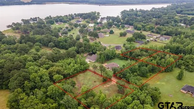 an aerial view of residential house with outdoor space and trees all around