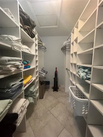 a view of walk in closet with clothes and shoes