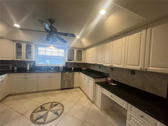 a large kitchen with stainless steel appliances granite countertop a sink and cabinets