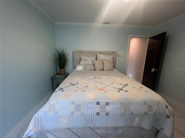 a bedroom with a bed and a potted plant