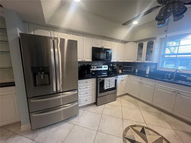 a kitchen with granite countertop a refrigerator and a sink