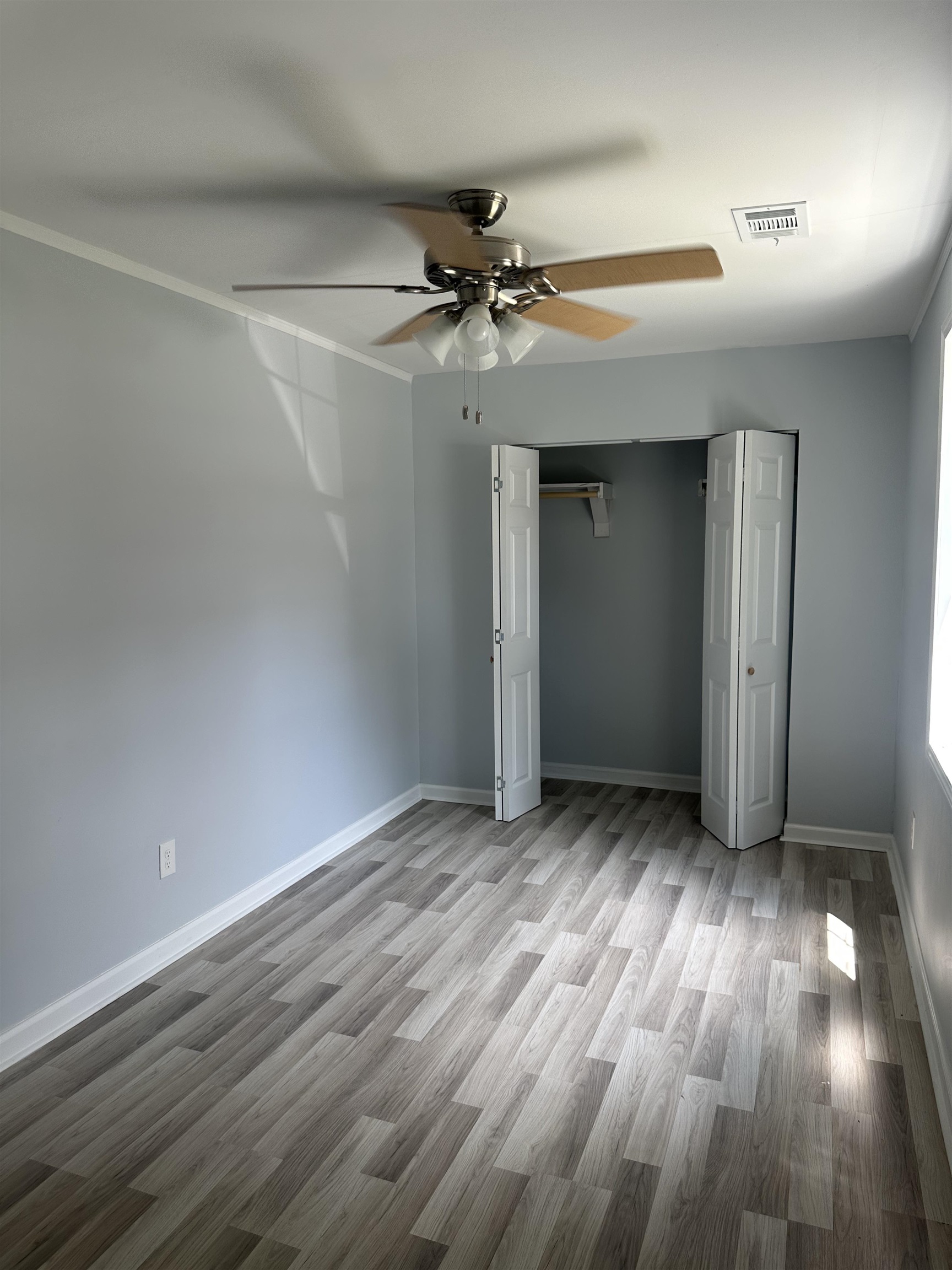 3402 Lakeview Road Memphis, TN 38116 - Photo 12 of 30 Unfurnished bedroom featuring wood finished floors, ceiling fan, a closet, and crown molding