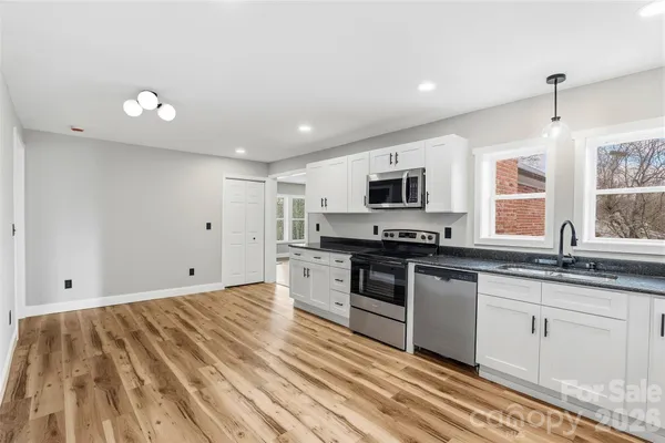a kitchen with granite countertop white cabinets and appliances