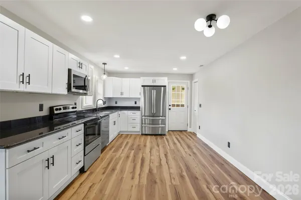 a kitchen with a sink stainless steel appliances and white cabinets