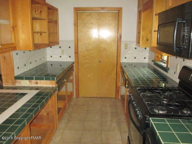 1323 Millcreek Road Newfoundland, PA 18445 - Photo 9 of 18 a kitchen with stainless steel appliances granite countertop a stove and a wooden cabinets