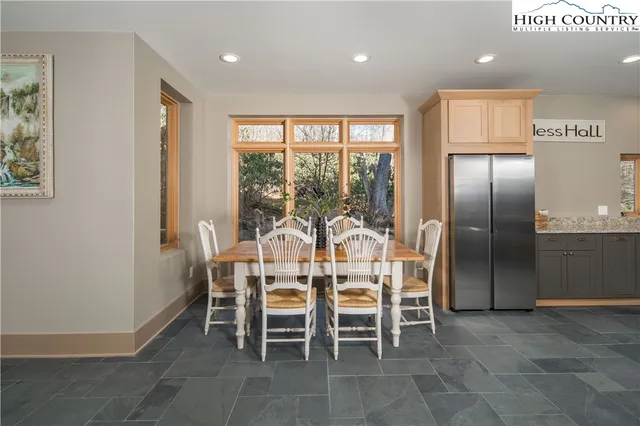 a dining room with furniture and a floor to ceiling window