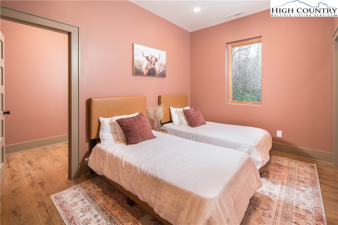 216 Greenbriar Road Beech Mountain, NC 28604 - Photo 24 of 50 a bedroom with a bed and wooden floor