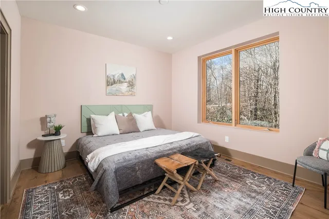 a bedroom with a bed and wooden floor