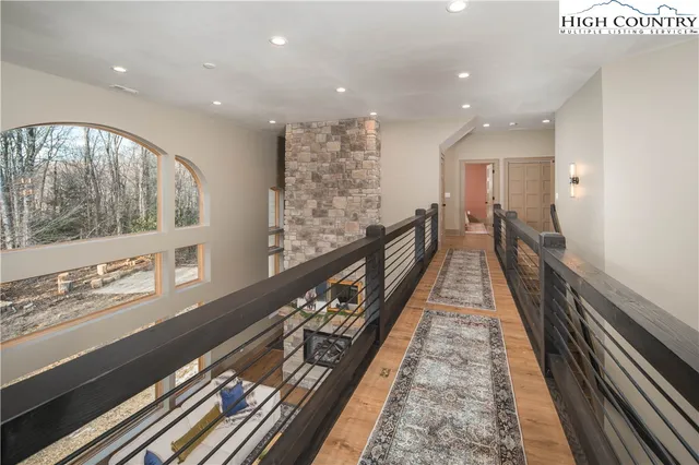 a view of a hallway with wooden floor and stairs
