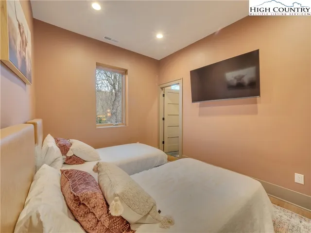 a bedroom with a large bed and a flat screen tv