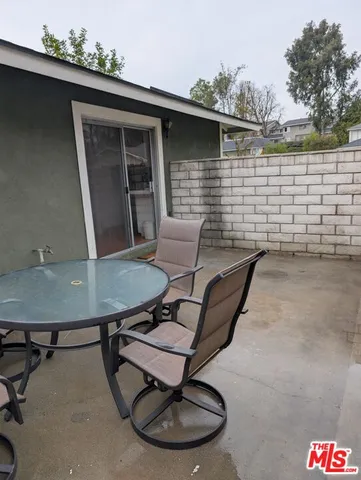 a backyard of a house with table and chairs