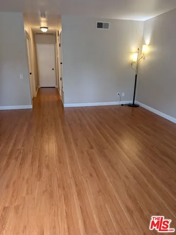 a view of empty room with wooden floor