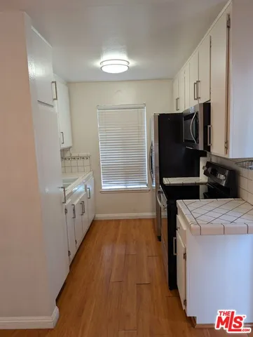 a kitchen with a refrigerator a stove top oven and a counter space