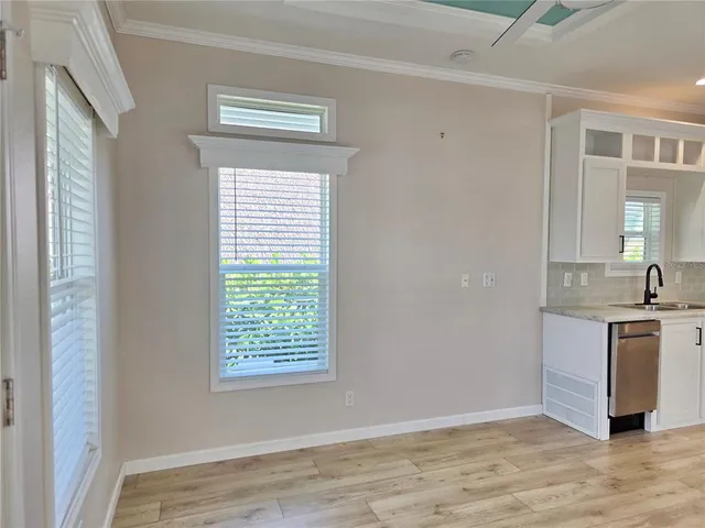 a view of an empty room with window and wooden floor
