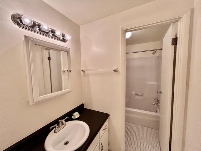 a bathroom with a sink a light fixture and a mirror