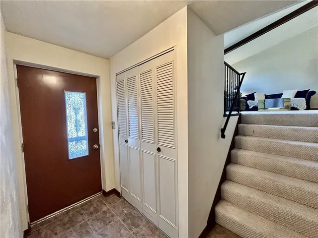 a view of a hallway with staircase and white walls