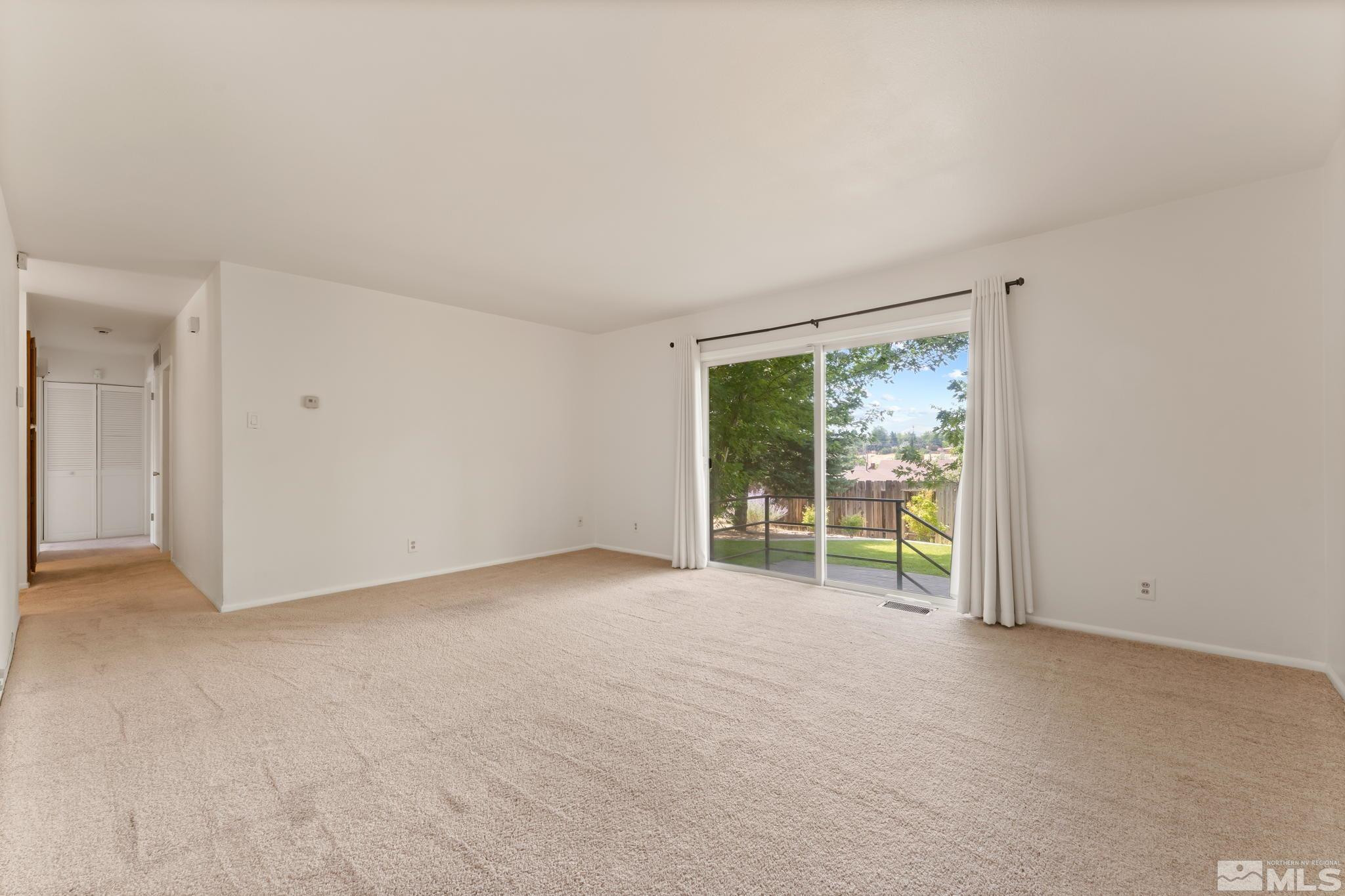 2710 Apollo Way Reno, NV 89503 - Photo 5 of 32 an empty room with floor to ceiling window and an outdoor view