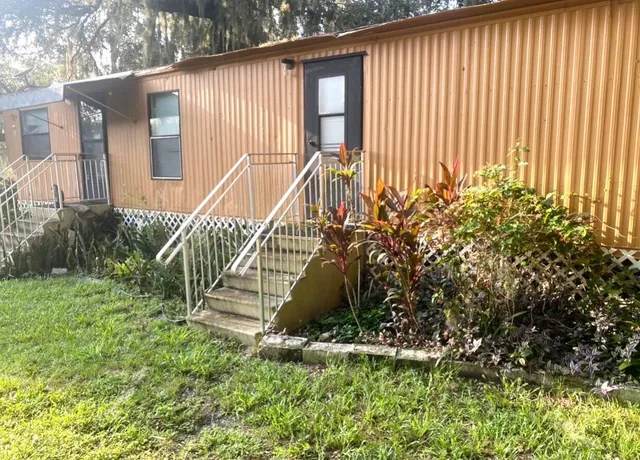 a view of a house with a yard and plants