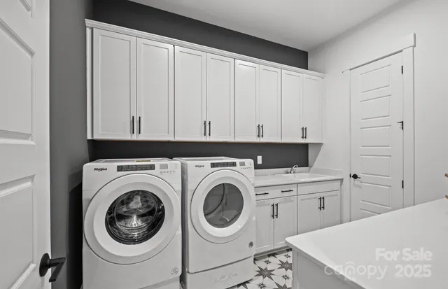 a utility room with sink dryer and washer