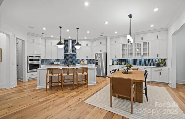 a large kitchen with kitchen island a dining table and chairs